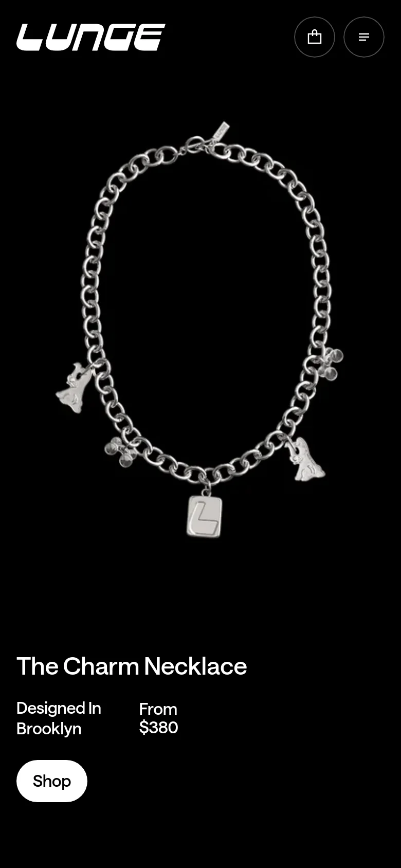 The mobile version maintains the minimalist black and white aesthetic, centering the silver charm necklace imagery and text for a vertical view. The headline, product details, and 'Shop' button are stacked vertically below the main image, with the brand logo and navigation icons positioned at the top of the screen.