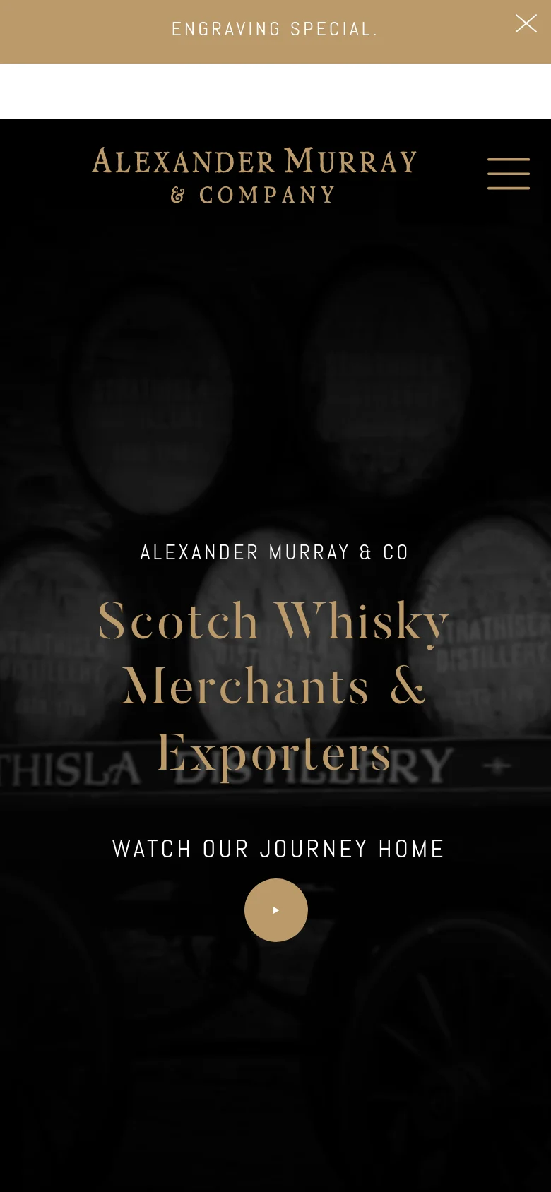 The mobile version maintains the dark distillery background and gold typography but uses a simplified layout. The headline is centered, and the primary call to action is a large, circular play button labeled 'WATCH OUR JOURNEY HOME'. The top navigation is condensed into a hamburger menu icon, and the announcement bar remains at the top.