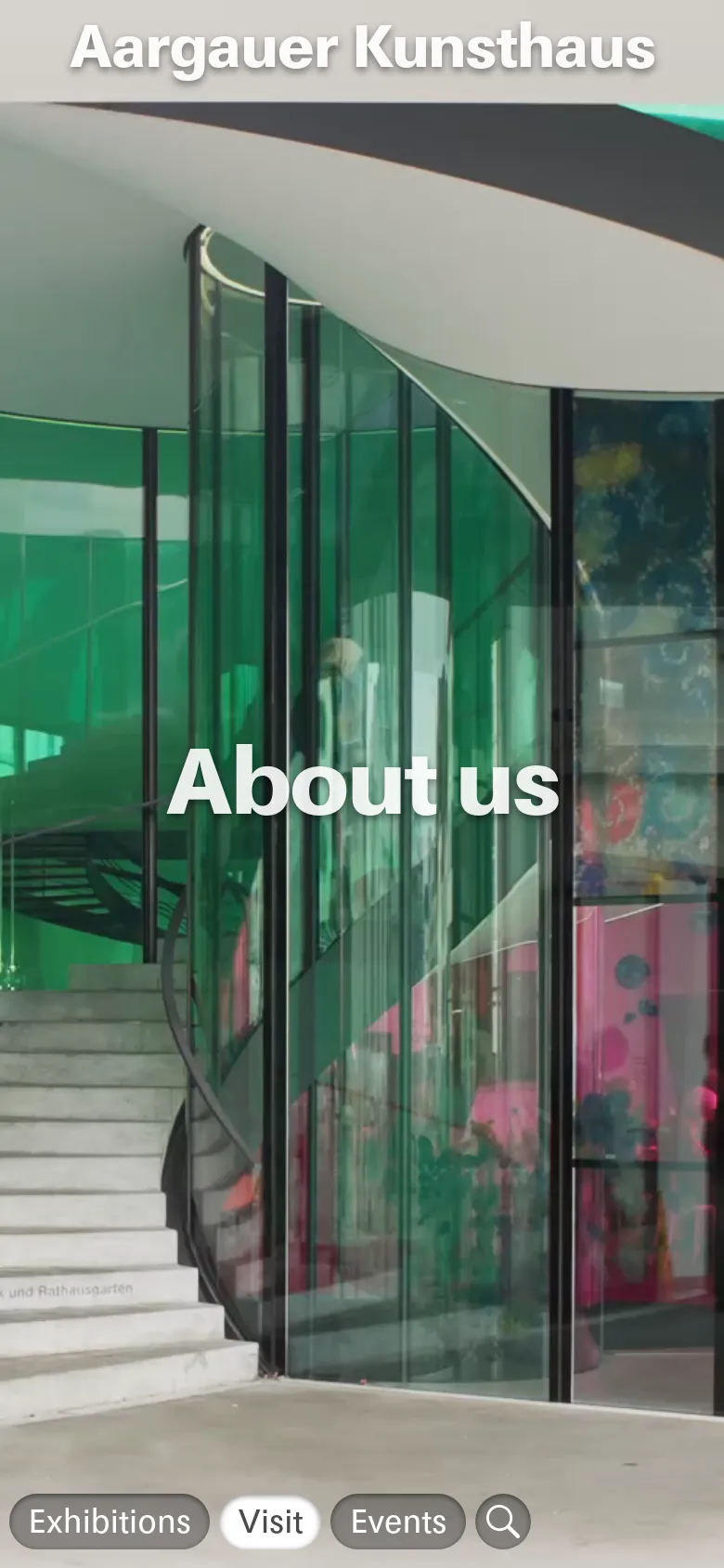 The mobile version displays the same hero image of the green glass architecture and 'About us' headline, but the navigation is condensed into a bottom bar. This bottom bar contains pill-shaped buttons for Exhibitions, Visit, and Events, plus a search icon, while the museum name is moved to the top.