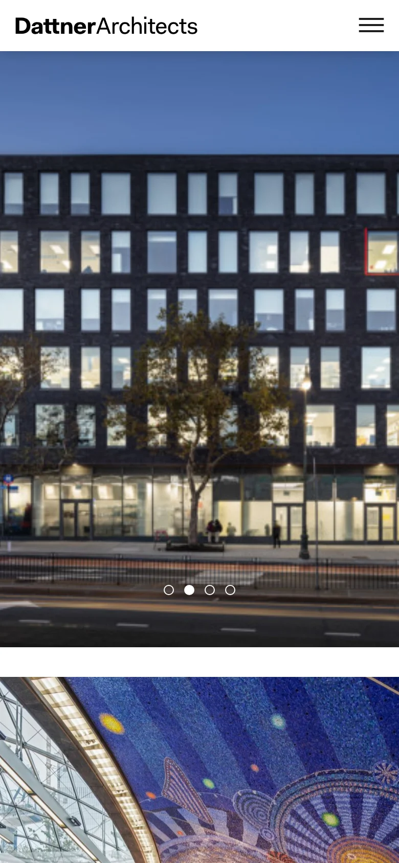 The mobile version displays the Dattner Architects logo at the top left with a hamburger menu icon on the right for navigation. The hero image of the dark brick building remains prominent, spanning the width of the screen, with pagination dots centered at the bottom of the image to indicate a carousel.