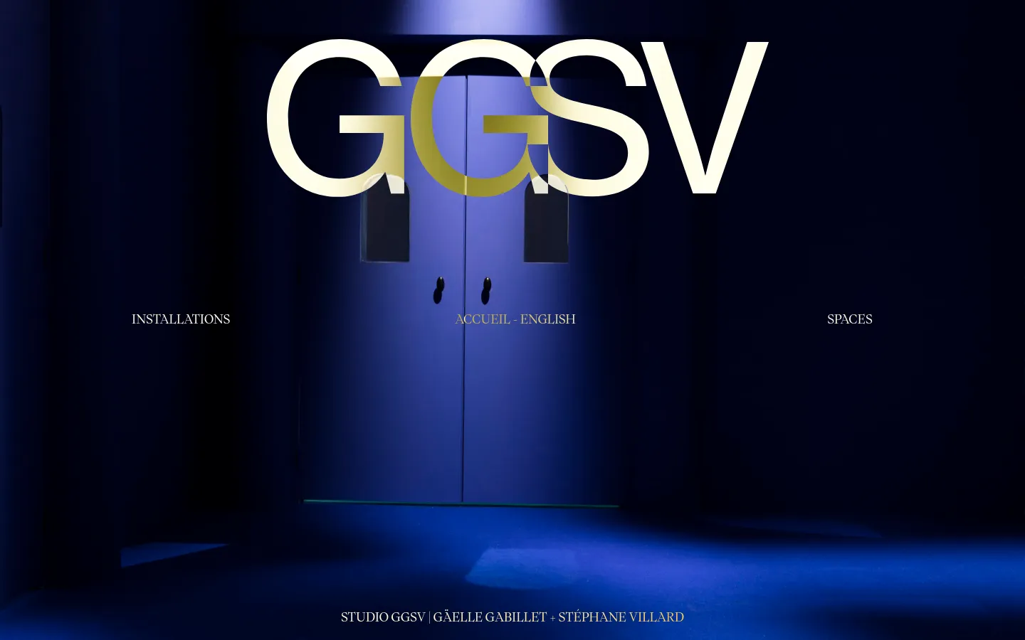 The desktop homepage features a dark blue, cinematic hero image of a doorway under a spotlight. Large, cream-colored 'GGSV' text dominates the top, with navigation links for 'INSTALLATIONS', 'ACCUEIL - ENGLISH', and 'SPACES' centered in the middle. The footer contains the text 'STUDIO GGSV | GÄELLE GABILLET + STÉPHANE VILLARD'.