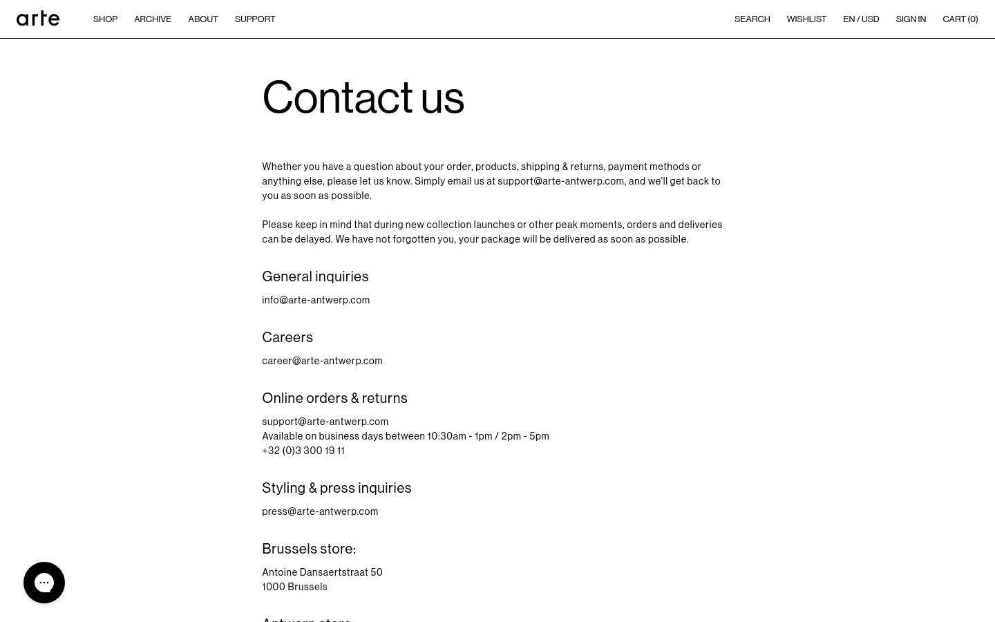 The desktop Contact page features a minimalist white layout with black text and a clean navigation bar at the top. The content is left-aligned, presenting a large 'Contact us' headline followed by informational text and categorized contact details including email addresses for general inquiries, careers, orders, and press, as well as physical store addresses. A small black circular floating button is visible in the bottom left corner.
