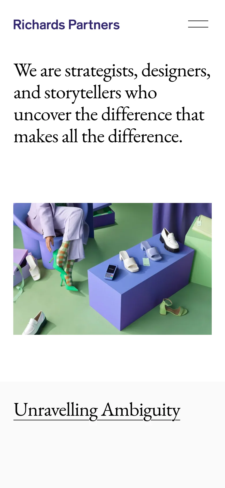The mobile version presents a simplified vertical layout with the brand name on the left and a hamburger menu icon on the right. The large serif headline is stacked vertically above a centered, rectangular hero image showcasing colorful products on geometric pedestals.