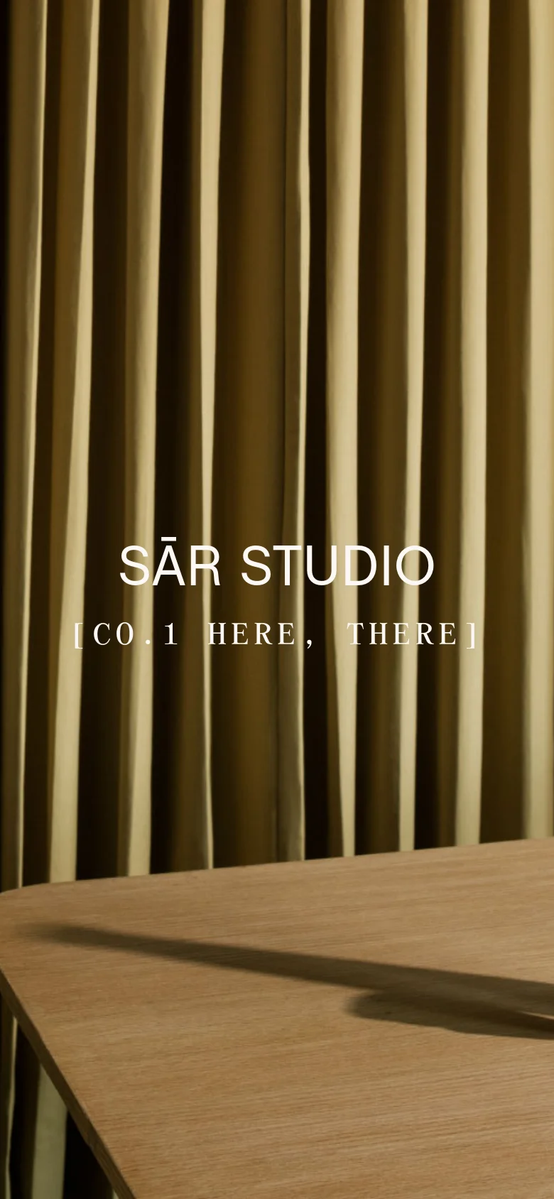 The mobile version presents a vertically cropped version of the hero image, focusing on the texture of the gold curtains and the wooden table surface. The brand name 'SĀR STUDIO' and tagline remain centered in white text, but the composition is tighter to fit the narrow portrait orientation of a smartphone screen.