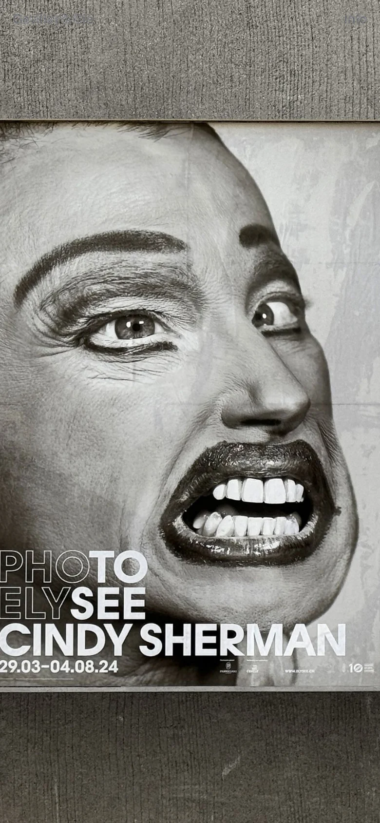The mobile version maintains the dark aesthetic and minimalist layout, but the central poster image is cropped to focus on a close-up, black and white photographic detail of a face with wide eyes and an open mouth. The typography 'PHOTO ELYSEE CINDY SHERMAN' is prominently displayed at the bottom of the frame.