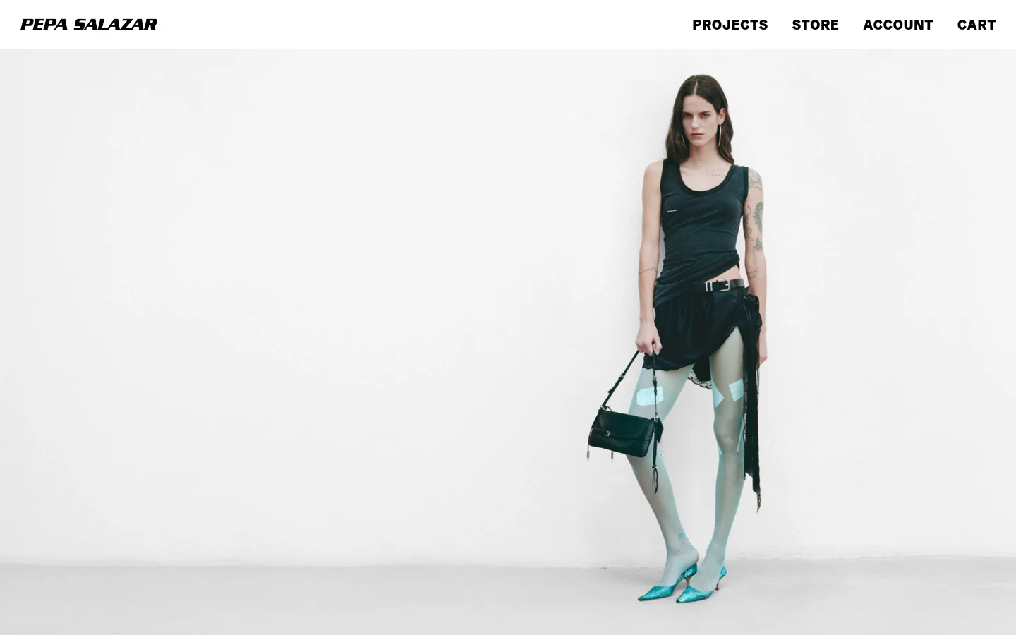 The desktop homepage features a minimalist white layout with the PEPA SALAZAR logo on the top left and navigation links for Projects, Store, Account, and Cart on the top right. A large hero image shows a model in dark clothing, light blue tights, and teal heels standing against a plain white background.