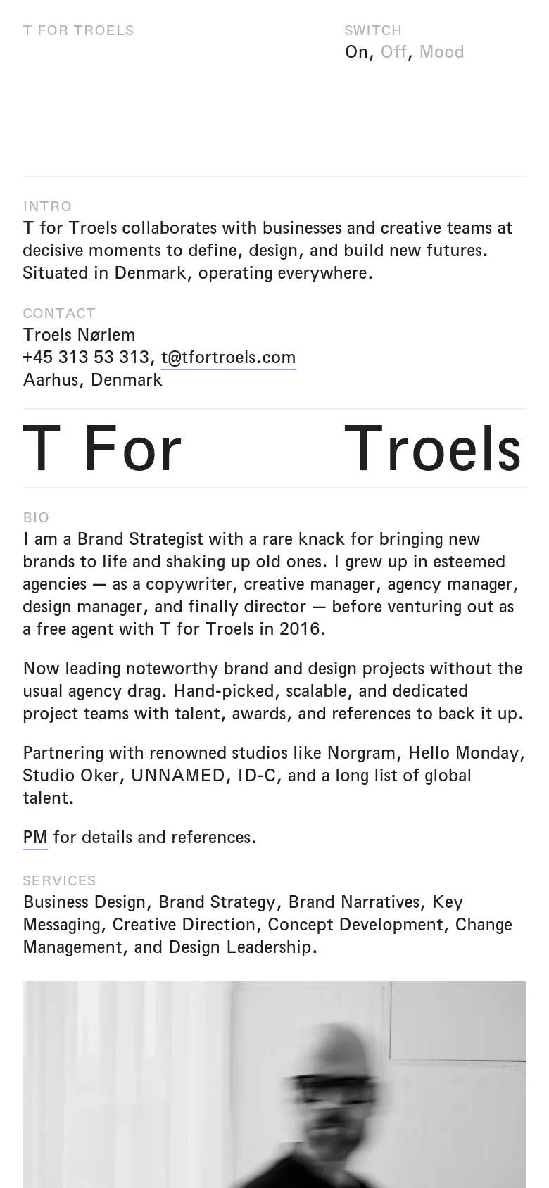 The mobile version maintains the minimalist black and white aesthetic but transitions to a single-column vertical layout. The large 'T For Troels' header is scaled down to fit the screen width, and text sections like Bio and Services are stacked vertically for easier scrolling on a narrow device.