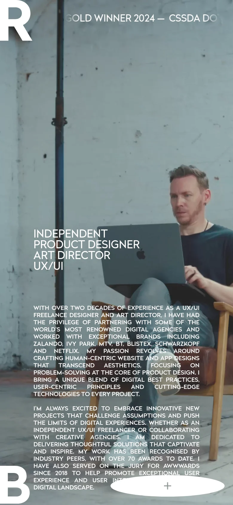 Mobile version of the homepage with a vertical layout, centering the hero portrait and large white typography. The text content is stacked vertically below the main heading, maintaining the minimalist design and high-contrast white text on a light background. Navigation and interactive elements like the plus icon are repositioned for a narrow viewport.