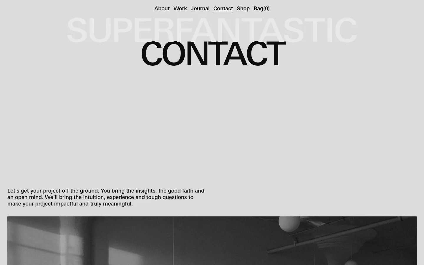 The desktop Contact page features a minimalist light gray background with large, bold black typography for the 'CONTACT' headline. Below the headline, a mission statement is followed by a wide, black-and-white cinematic photograph of three people in a studio setting. A navigation menu is visible at the top, and the layout uses generous whitespace to create a clean, professional aesthetic.