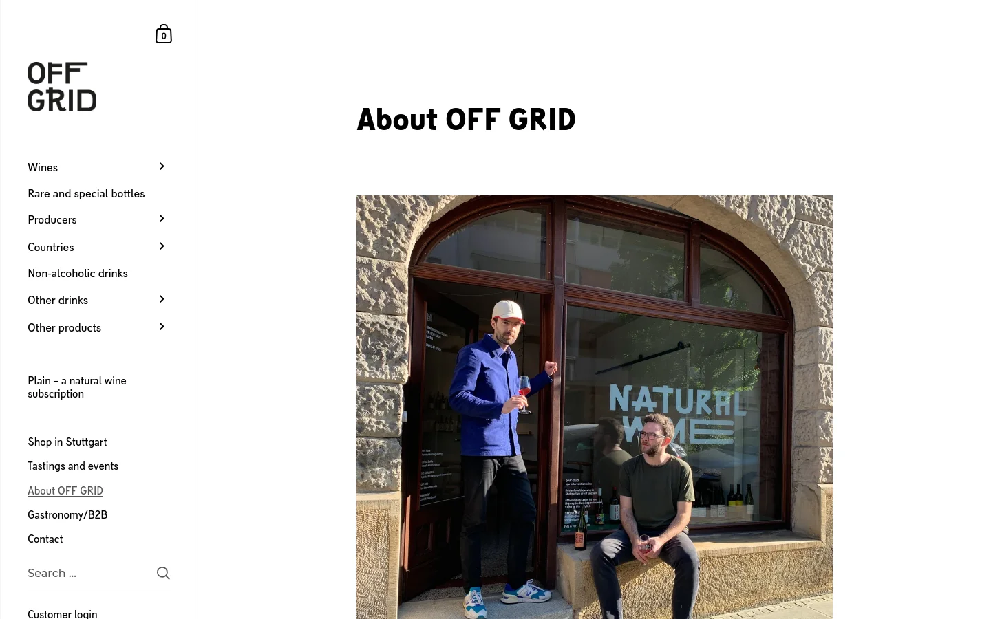 The desktop view shows a clean, minimalist layout with a white background and black text. A large headline reads 'About OFF GRID' above a hero image of two men standing and sitting in front of a shop window that says 'NATURAL WINE'. A sidebar on the left contains the brand logo and a vertical navigation menu with various wine categories and links.