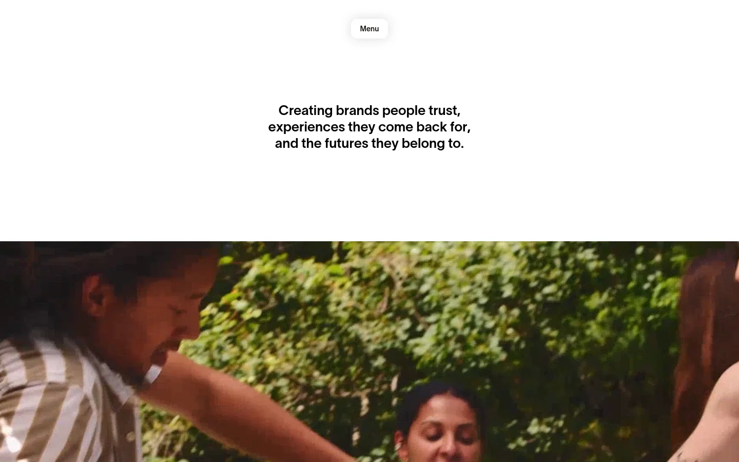 The desktop homepage for A-B-D agency features a minimalist white background with bold black typography. A large hero section includes a centered headline and a wide, cinematic photograph of people in a lush outdoor setting, with a small 'Menu' button at the top center.