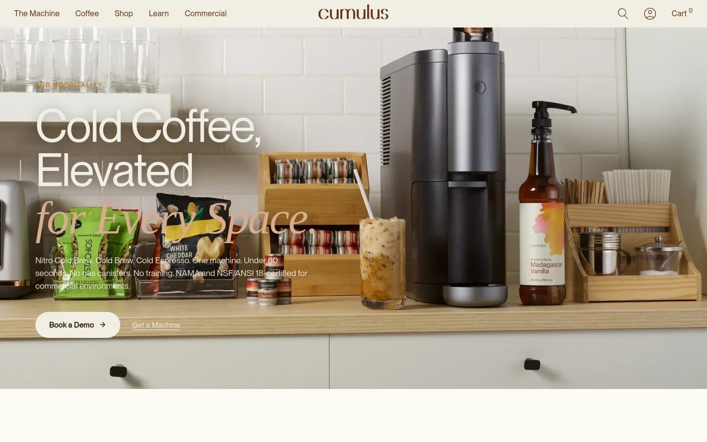 The desktop version features a large hero image of a professional coffee station with the Cumulus machine, syrup, and glassware against a white tiled wall. A headline reads 'Cold Coffee, Elevated for Every Space' with primary call-to-action buttons for 'Book a Demo' and 'Get a Machine' overlaid on the image. The layout follows with a clean white background, dark text, and a numbered list of benefits accompanied by a product shot of the sleek, dark grey machine.