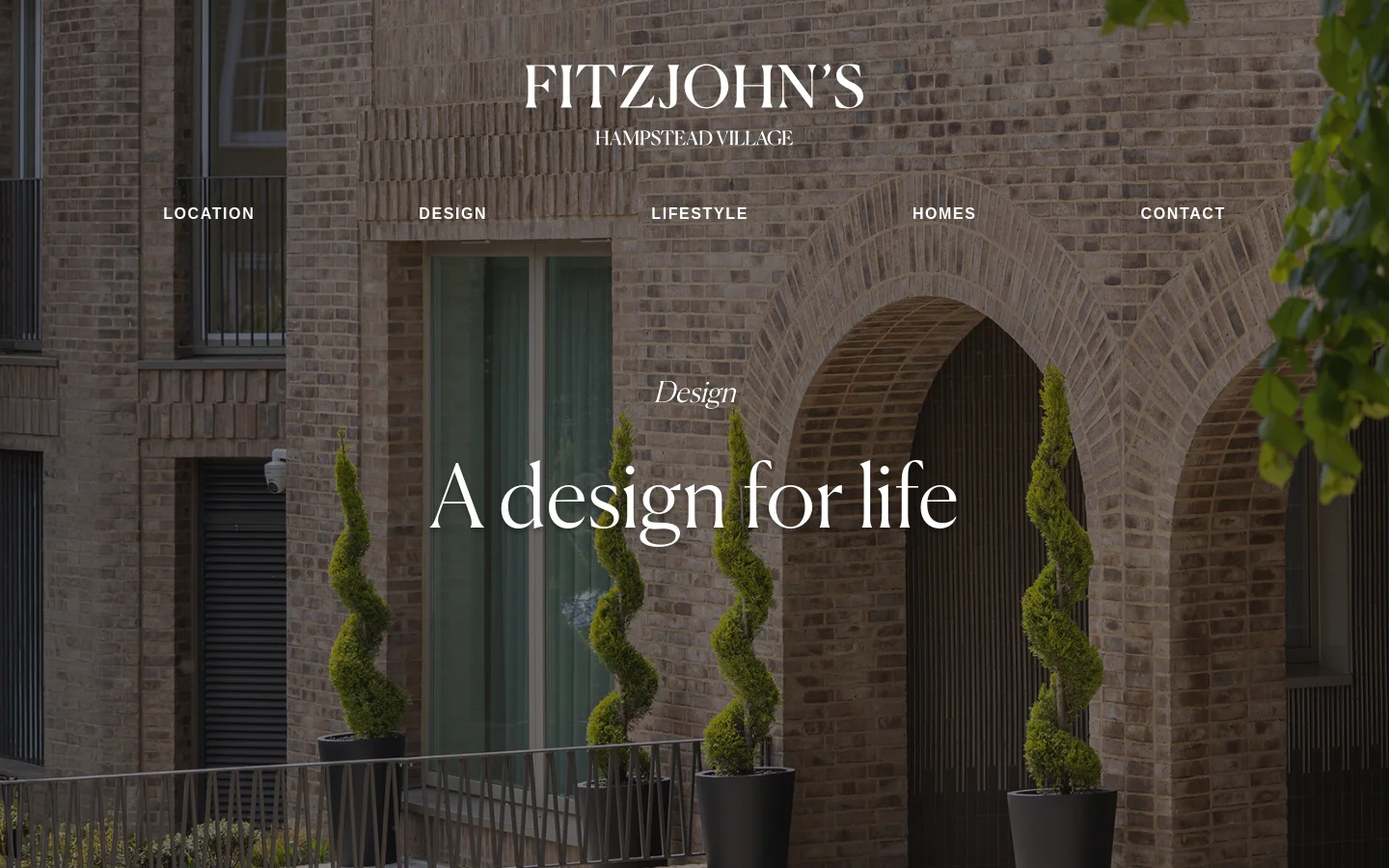 The desktop landing page features a full-width hero image of a modern brick building with arched entryways and spiral topiary trees. Centered white text displays the Fitzjohn's logo and the headline 'A design for life,' with a horizontal navigation menu below containing links for Location, Design, Lifestyle, Homes, and Contact.