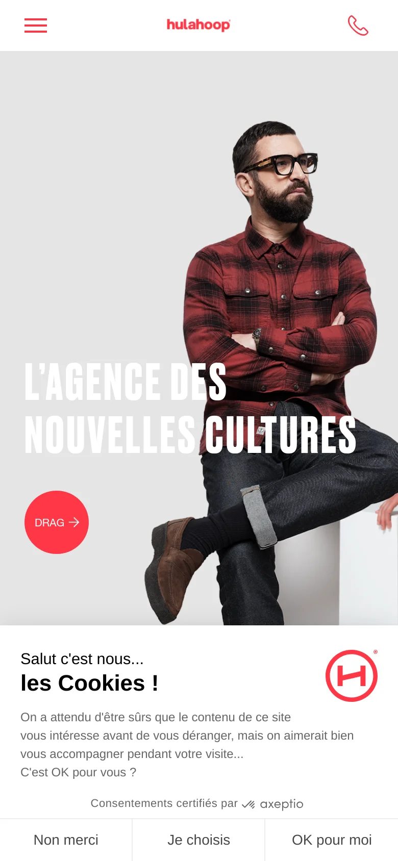 The mobile version presents a vertical layout with a cropped version of the team hero image, focusing on one individual. The headline 'L’AGENCE DES NOUVELLES CULTURES' is stacked, and a prominent red circular button with the text 'DRAG' and an arrow is visible. A cookie consent banner occupies the bottom portion of the screen with three distinct buttons.