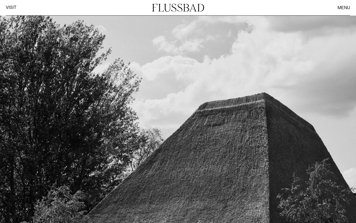 The desktop version features a large, black and white hero image of a thatched structure and trees against a cloudy sky. Below the image, the headline 'VISIT FLUSSBAD' appears in large black serif text, followed by a section for 'DIRECTIONS' with descriptive text. The layout is clean and minimalist with a white background and a simple navigation bar at the top.