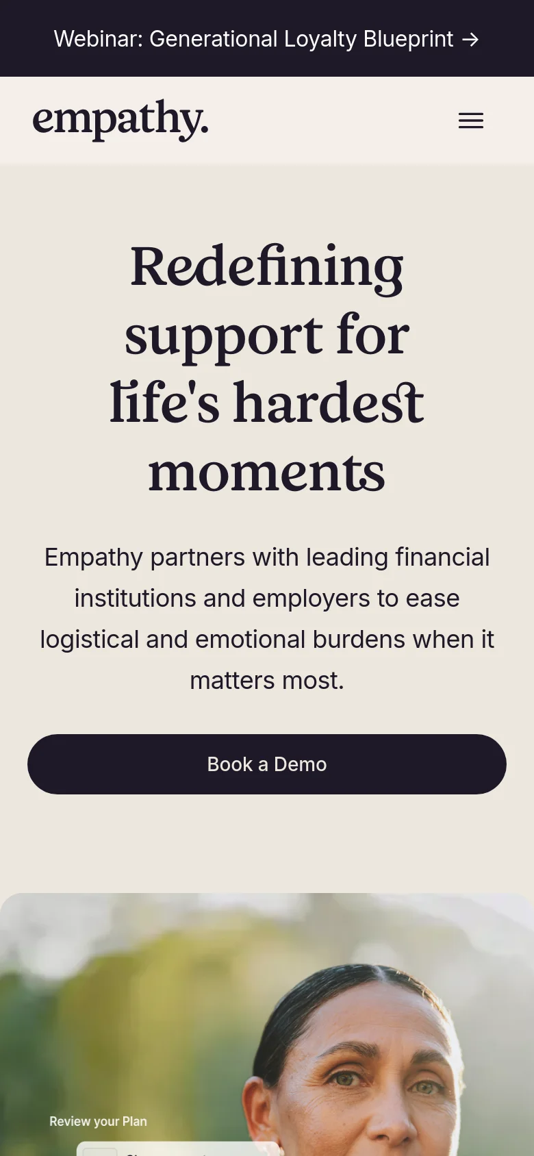 The mobile version presents a simplified vertical layout with the headline and subtext centered above a large 'Book a Demo' button. The hero image is partially visible at the bottom, and the top navigation is condensed into a hamburger menu icon next to the Empathy logo.