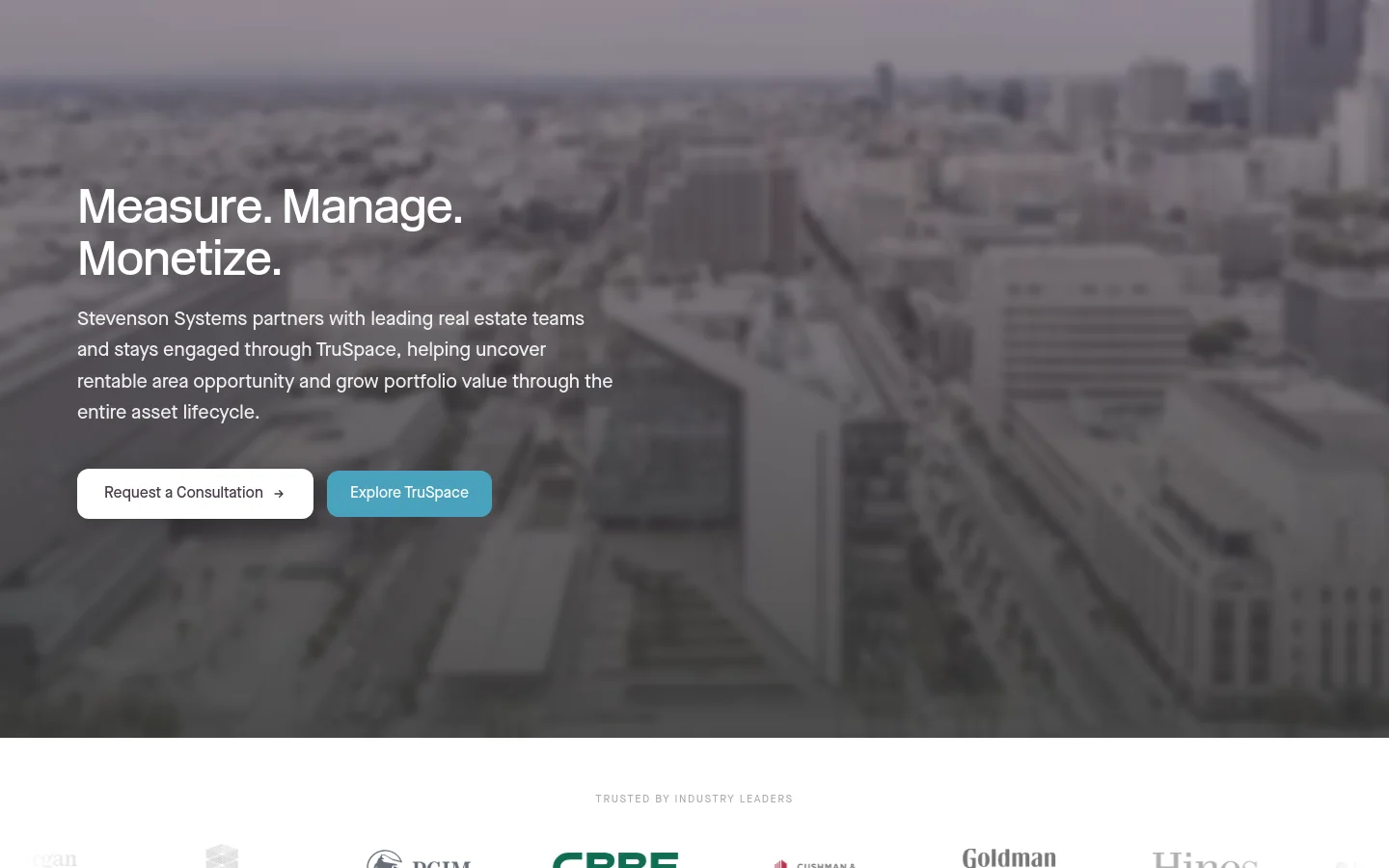 The desktop homepage features a large hero image of a grayscale cityscape with white text reading 'Measure. Manage. Monetize.' and a brief description of Stevenson Systems' services. Two primary buttons, 'Request a Consultation' and 'Explore TruSpace,' are positioned below the text. A section below the hero displays a row of industry leader logos under the heading 'TRUSTED BY INDUSTRY LEADERS'.
