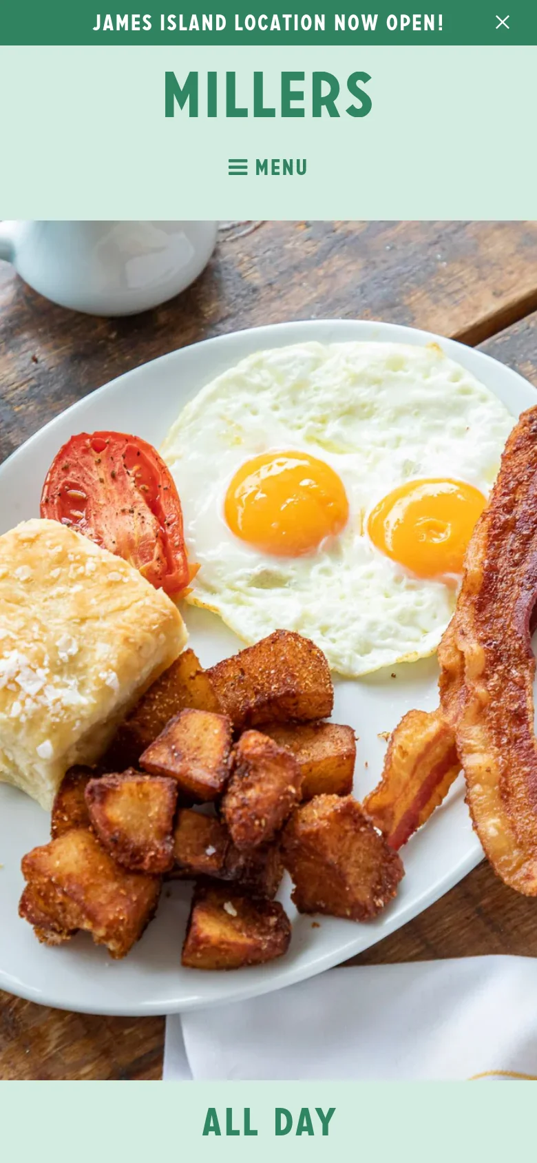 The mobile version uses a simplified layout with a centered logo and a hamburger menu icon labeled 'MENU' below it. The hero image of the breakfast plate remains prominent, filling the width of the screen, with the 'All Day' text positioned at the bottom. The top announcement bar and navigation links are condensed into the mobile menu interface.