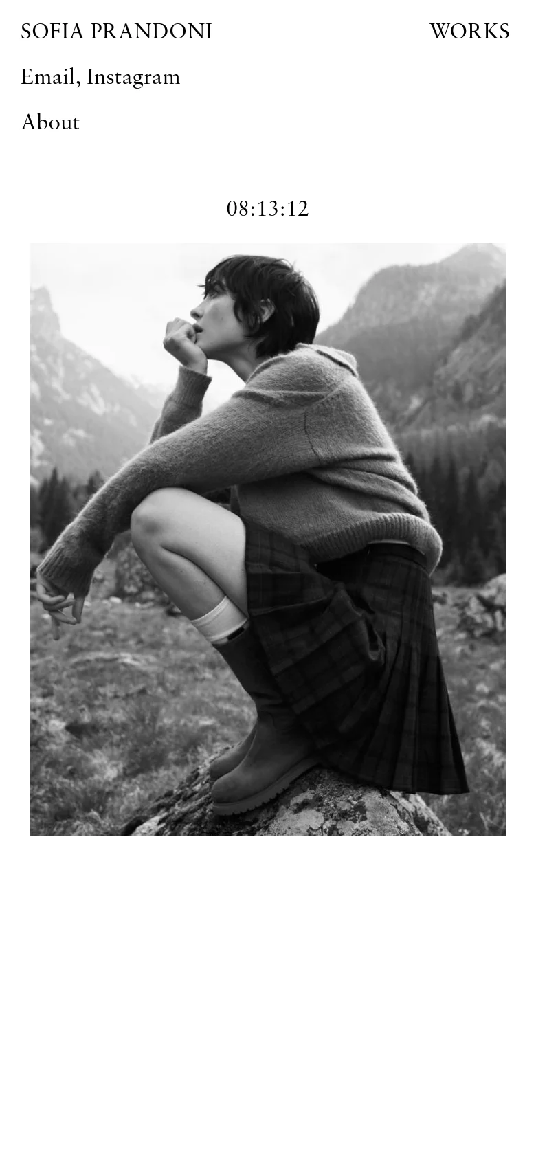 The mobile version maintains the minimalist black and white aesthetic, stacking the text elements vertically above the large hero image. The name, navigation links, and a digital clock are centered or left-aligned above the central photograph of a person in a mountainous setting.