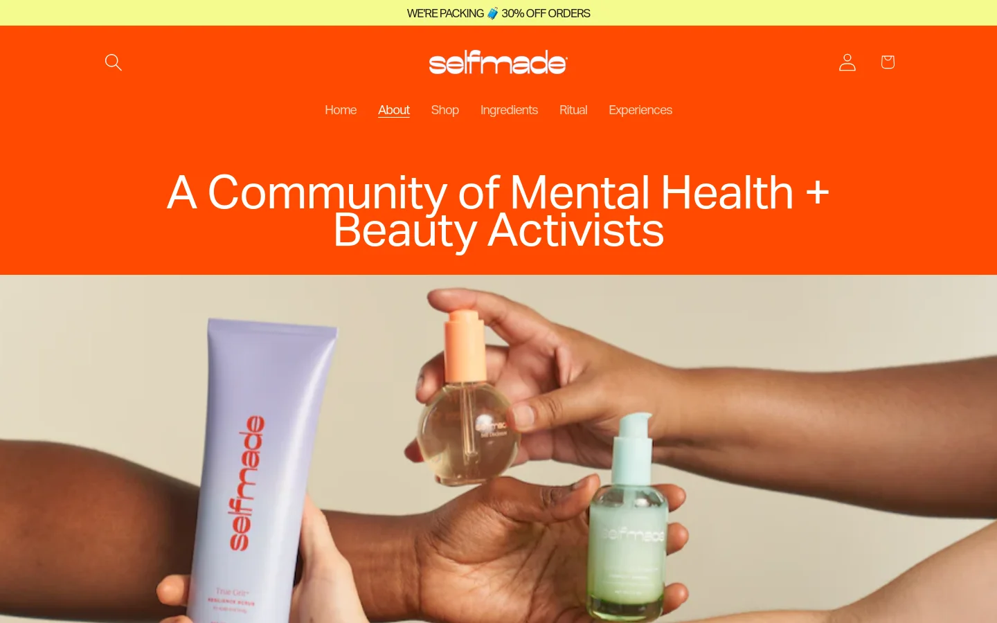 The desktop page features a bright orange header with the 'selfmade' logo and navigation links, centered around the large headline 'A Community of Mental Health + Beauty Activists'. Below the headline, a wide hero image shows hands holding various skincare products against a neutral background. The layout transitions into a clean, text-heavy section with a white background detailing the brand's origin story and founder information.