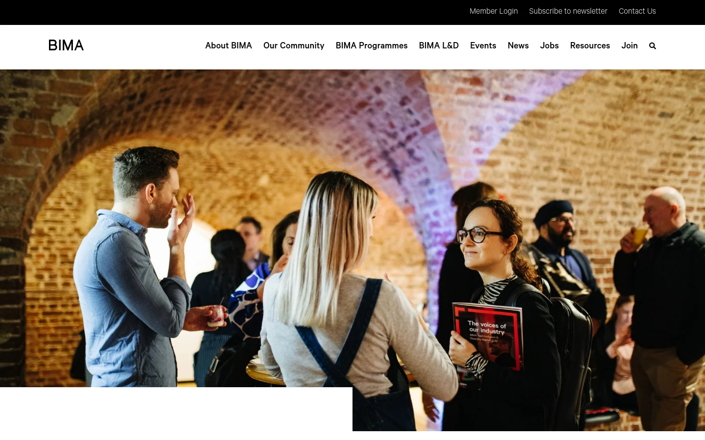 The desktop page features a large hero image of people networking in a brick-arched room, with a white navigation bar containing the BIMA logo and menu links. Below the hero image, the 'Contact Us' heading appears in large bold text next to a red accent line, followed by introductory text about the BIMA community.