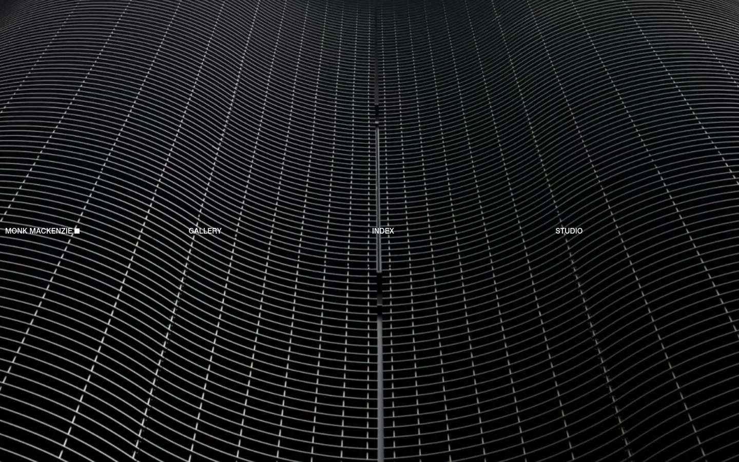 The desktop homepage features a dark, minimalist design with a large background image of a black, undulating metallic grid structure. White text links for 'MONK MACKENZIE', 'GALLERY', 'INDEX', and 'STUDIO' are spaced horizontally across the center of the screen.