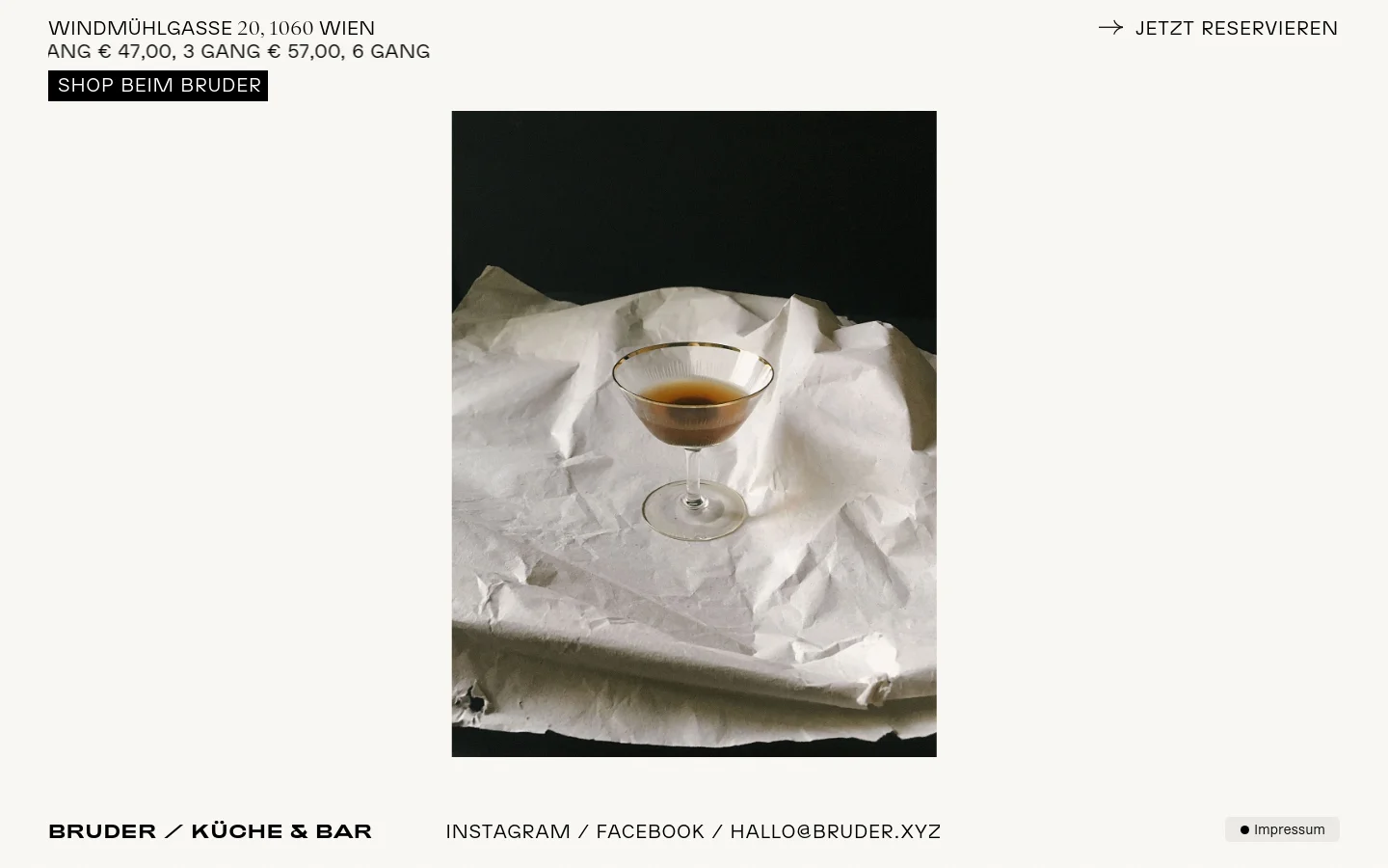 The desktop homepage for Bruder / Küche & Bar features a minimalist white background with a large hero image of a cocktail on crumpled paper. The layout includes the restaurant name, address, and menu pricing at the top, followed by a grid of food and drink photography, and navigation links for Instagram, Facebook, and email at the bottom.