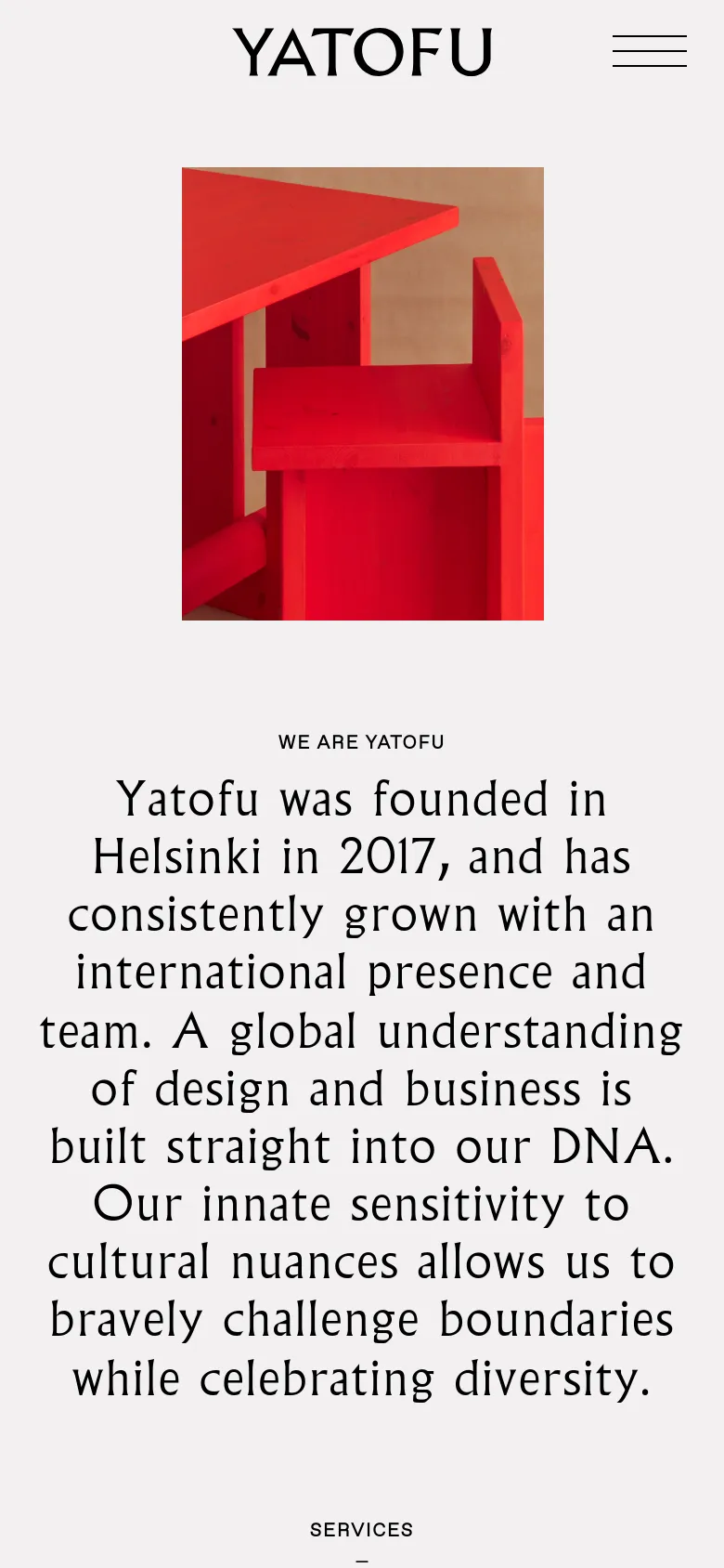 The mobile version presents a vertically stacked layout, starting with the 'YATOFU' logo and a hamburger menu icon at the top. The large red furniture image is centered, followed by the company introduction text in a single column. The design maintains a clean aesthetic with high contrast between the dark text and light background.