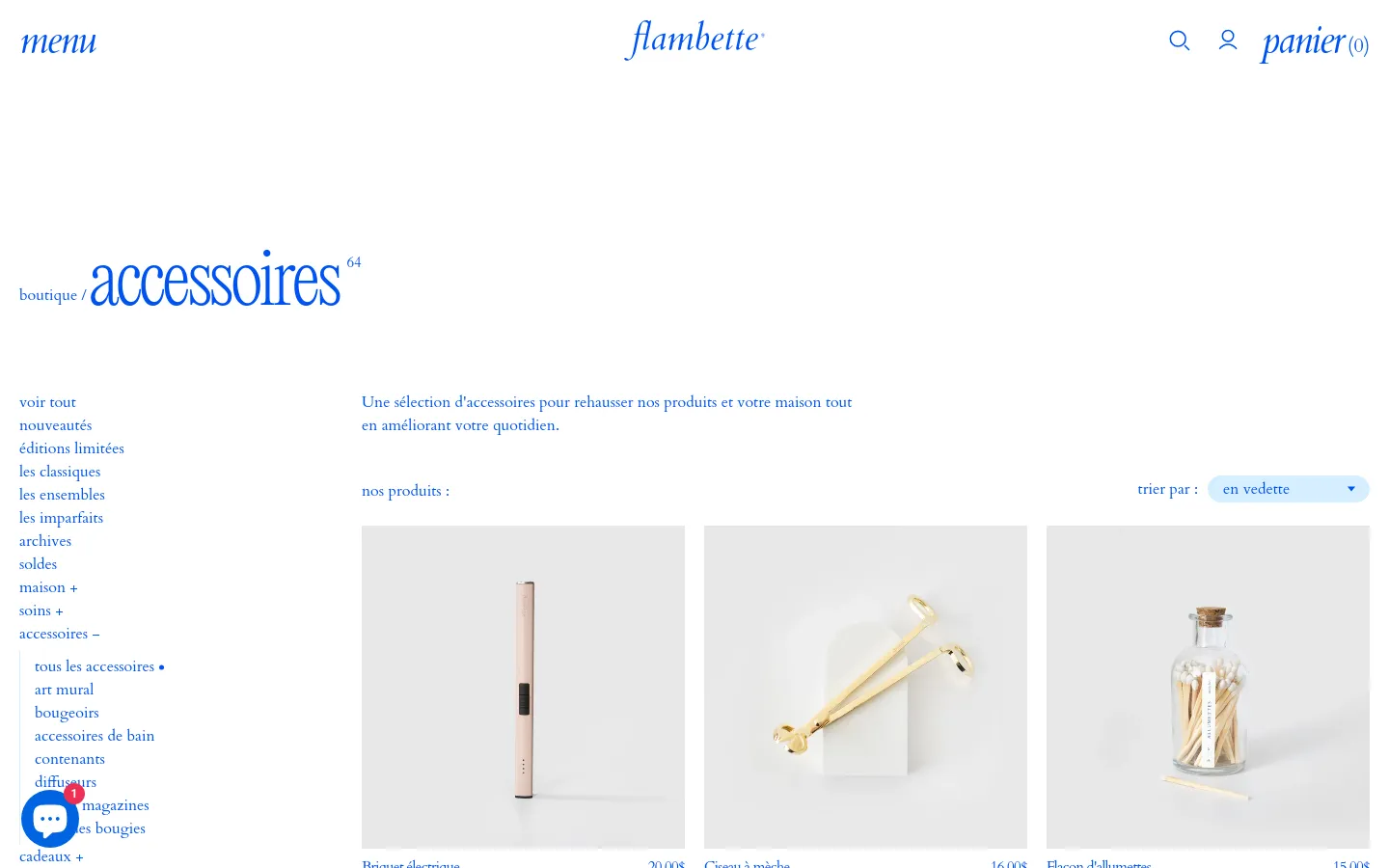 The desktop version of the Flambette accessories page features a minimalist white layout with blue serif typography. A large 'accessoires' headline is followed by a brief description and a product grid showcasing items like an electric lighter and wick scissors against light backgrounds. A left-hand sidebar provides extensive navigation links for various product categories.
