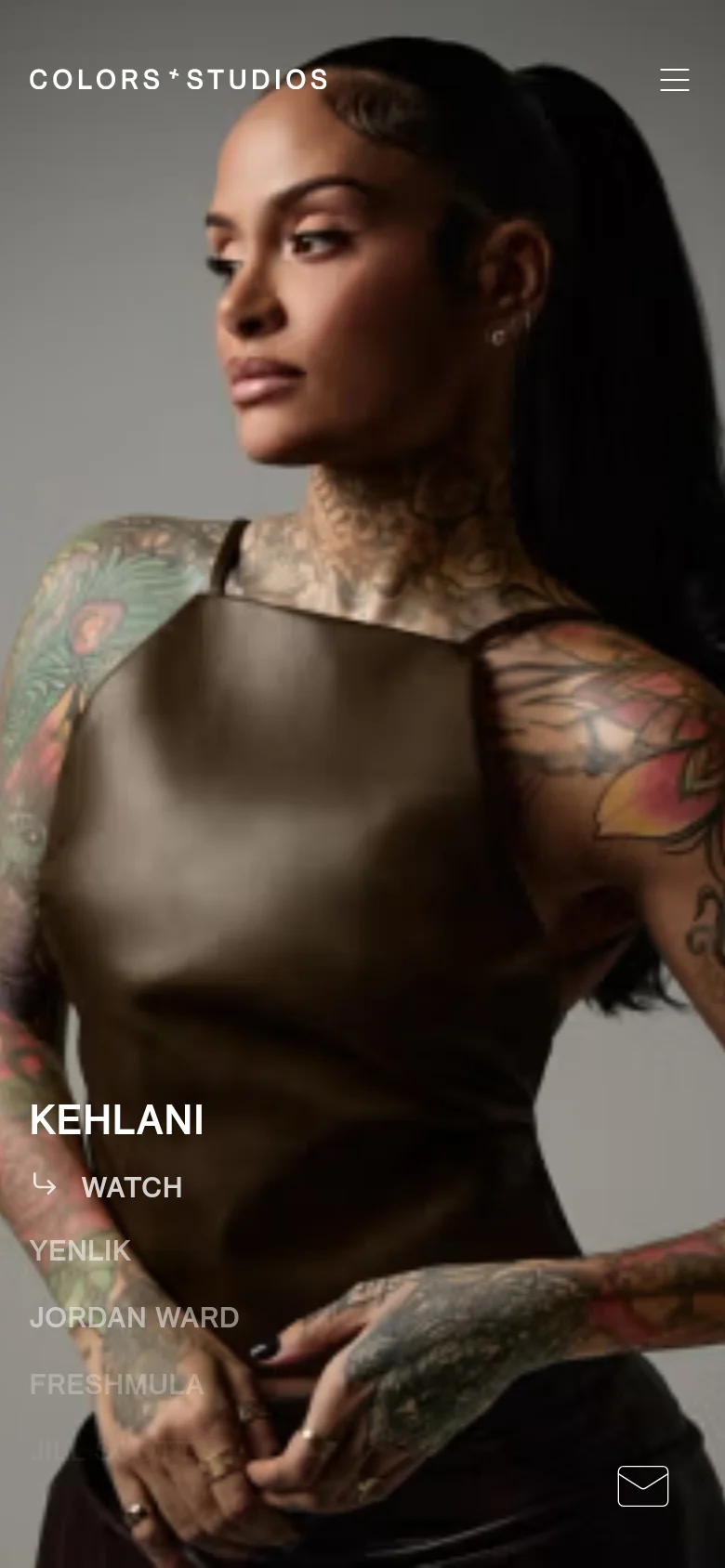 The mobile version presents a vertically oriented, full-screen hero image of Kehlani with a simplified layout. The artist's name and 'WATCH' call to action are positioned in the lower-left, while a hamburger menu and an envelope icon are located at the top and bottom right, respectively.