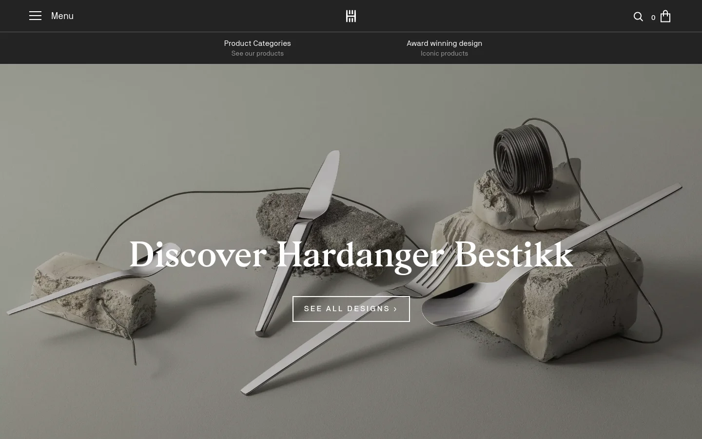 The desktop homepage features a large hero image of minimalist silver cutlery arranged artistically on stone blocks against a neutral background. A prominent headline reads 'Discover Hardanger Bestikk' with a 'SEE ALL DESIGNS' call-to-action button. Below the hero section, a grid displays bestselling cutlery sets with product images, names, and prices.