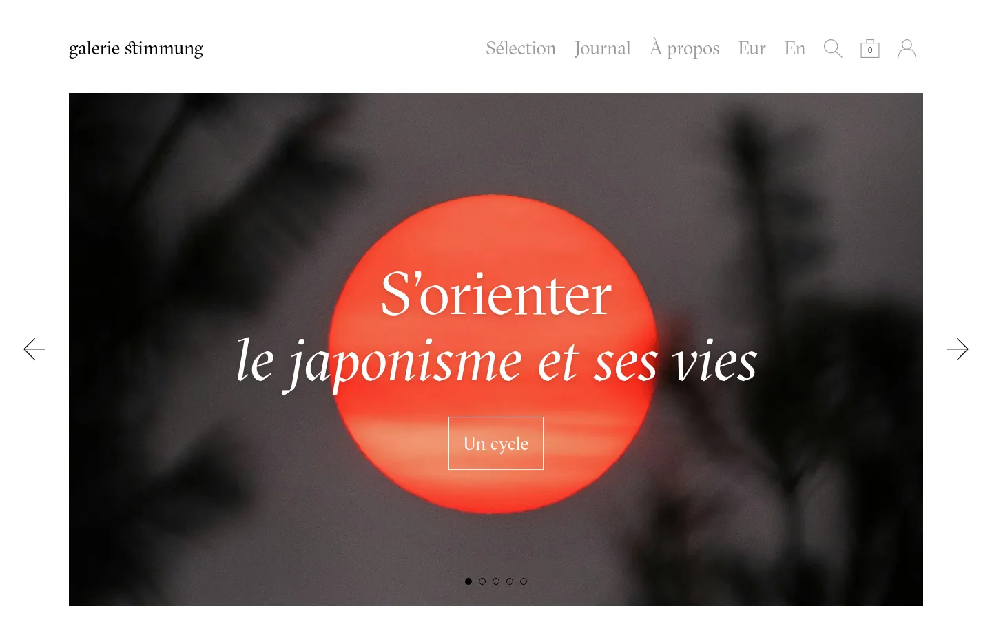 The desktop homepage features a minimalist white header with the 'galerie stimmung' logo and navigation links for Sélection, Journal, and À propos. A large hero slider displays a striking image of a red sun against a dark silhouette background with the text 'S'orienter le japonisme et ses vies' and a button labeled 'Un cycle'. Below the slider, a 'Nouveautés' section displays a grid of art objects with titles and prices.
