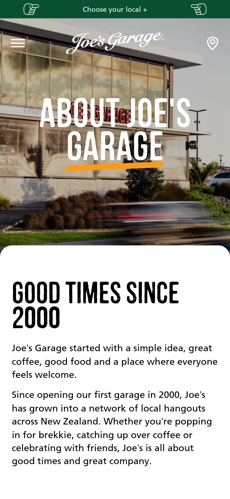 The mobile version presents a vertically stacked layout starting with a full-width hero image of a restaurant exterior overlaid with the 'ABOUT JOE'S GARAGE' title. The navigation is condensed into a hamburger menu and a location selector at the top. Content sections follow with large, bold headings and single-column text and imagery for easy scrolling.
